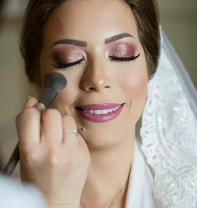 Finishing a bride's makeup with a powder brush